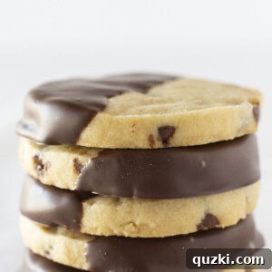 Perfectly baked chocolate chip shortbread cookies stacked on each other, invitingly displaying their delicious texture and golden edges.