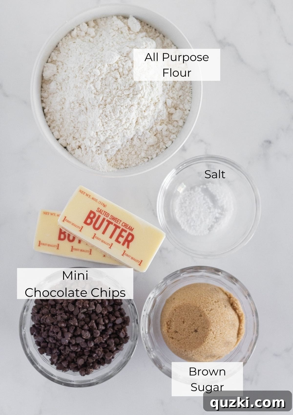 Essential ingredients artfully arranged to make chocolate chip shortbread, including golden butter, brown sugar, white flour, a pinch of salt, and a pile of mini chocolate chips.