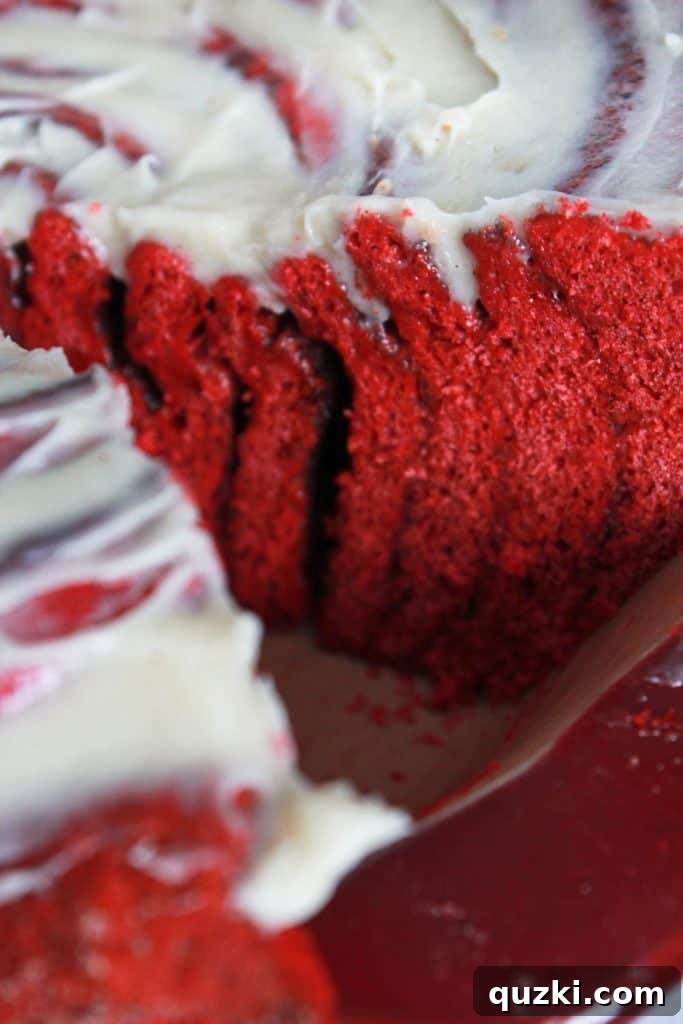 Close-up of the delicious Red Velvet Cinnamon Roll Cake, frosted and ready to serve, highlighting its inviting texture and vibrant color.
