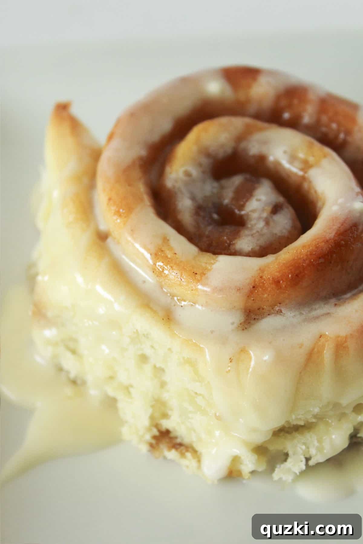 A one hour cinnamon roll ready to be served, topped with cream cheese frosting.