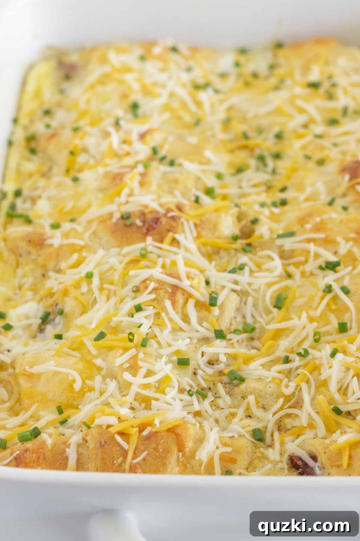 Baked ham breakfast casserole topped with fresh chopped chives, a perfect make-ahead dish.