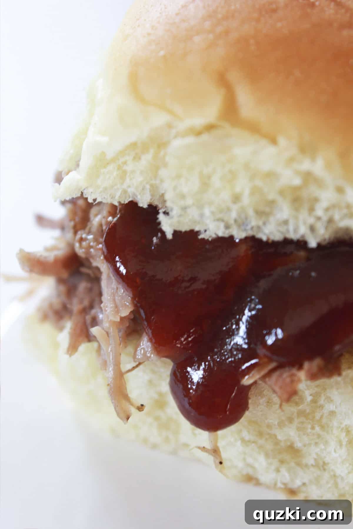 Tender crock pot pulled pork served on a roll with BBQ sauce, a perfect family meal.