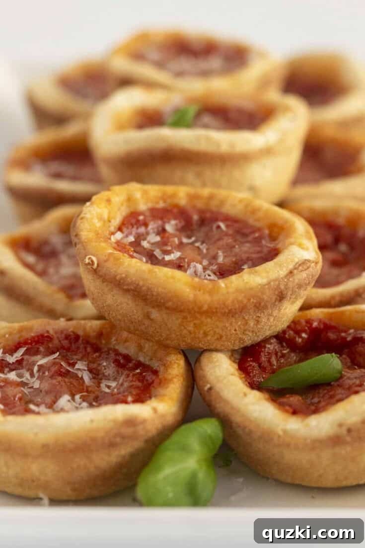 Delectable Mini Chicago Deep Dish Pizzas, baked perfectly in a muffin tin, showcasing their signature thick crusts, rich tomato sauce, and abundant melted cheese and toppings.