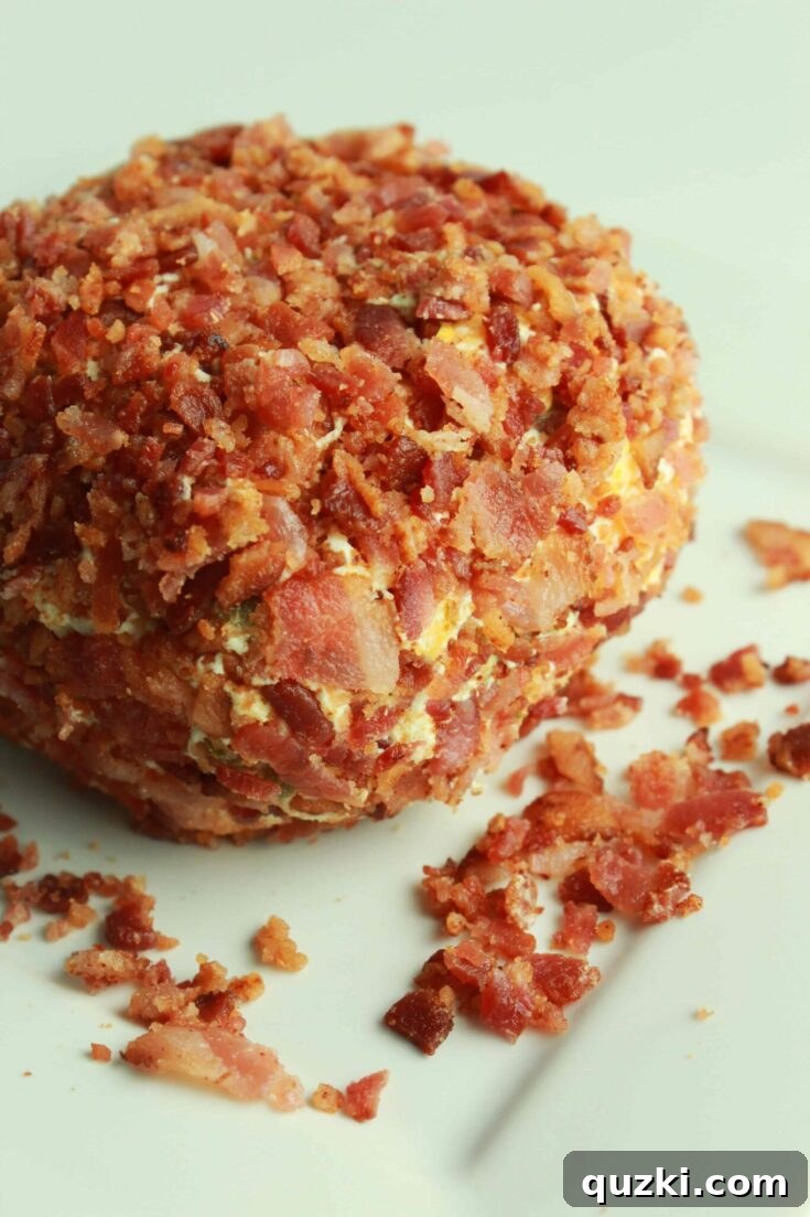 A festive Jalapeño Popper Cheese Ball, beautifully coated in crushed tortilla chips and served alongside an array of crisp crackers, perfect for dipping.