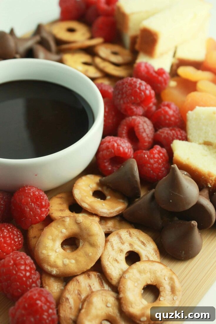 A beautifully curated Savory and Sweet Party Plate, artfully combining assorted cheeses, cured meats, fresh and dried fruits, nuts, chocolates, and various crackers for a balanced festive spread.