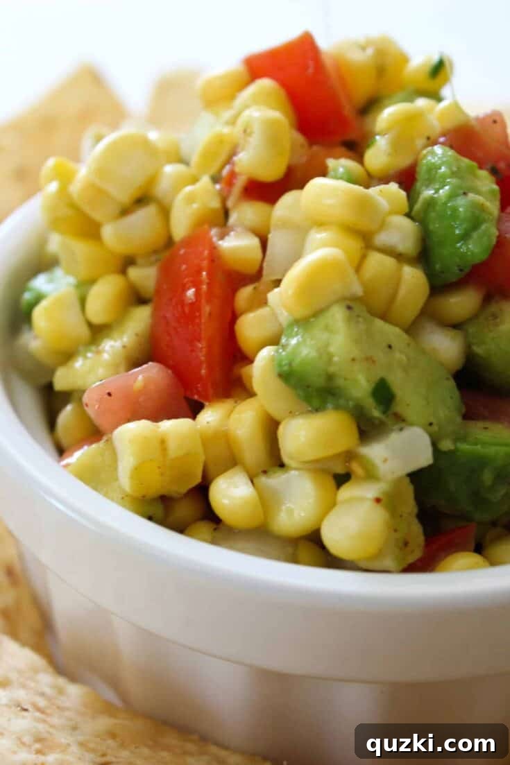 A vibrant and refreshing bowl of Easy Cowboy Corn Salsa, brimming with sweet corn, black beans, diced bell peppers, red onion, and fresh cilantro, perfect with tortilla chips.
