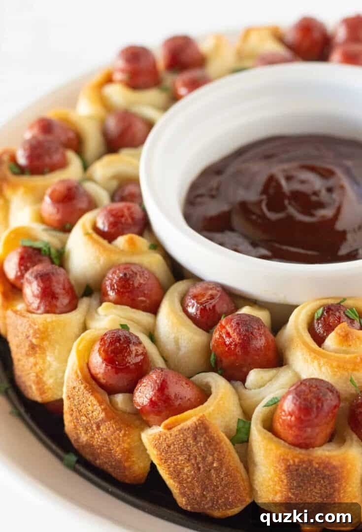 A beautifully arranged Pigs in a Blanket Wreath, featuring golden-brown little smokies wrapped in flaky crescent dough, perfect for sharing at a New Year's party.