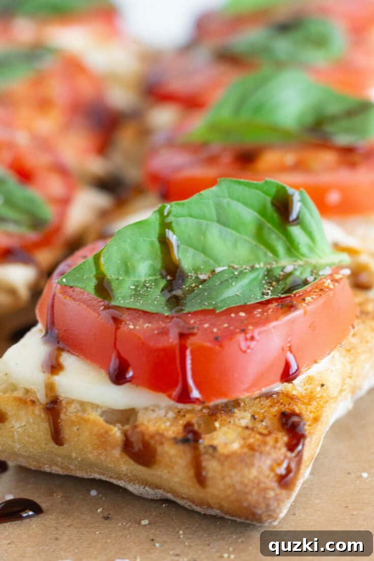 Elegant Caprese Toast adorned with melted mozzarella, bright red cherry tomato halves, and fragrant fresh basil leaves, served on perfectly toasted bread.