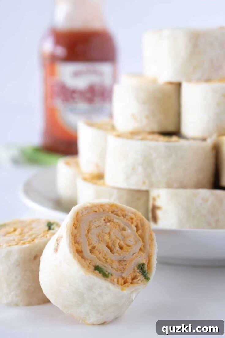 Spicy and flavorful Buffalo Chicken Tortilla Wraps, neatly sliced into spiral pinwheels, showcasing the creamy buffalo chicken filling.