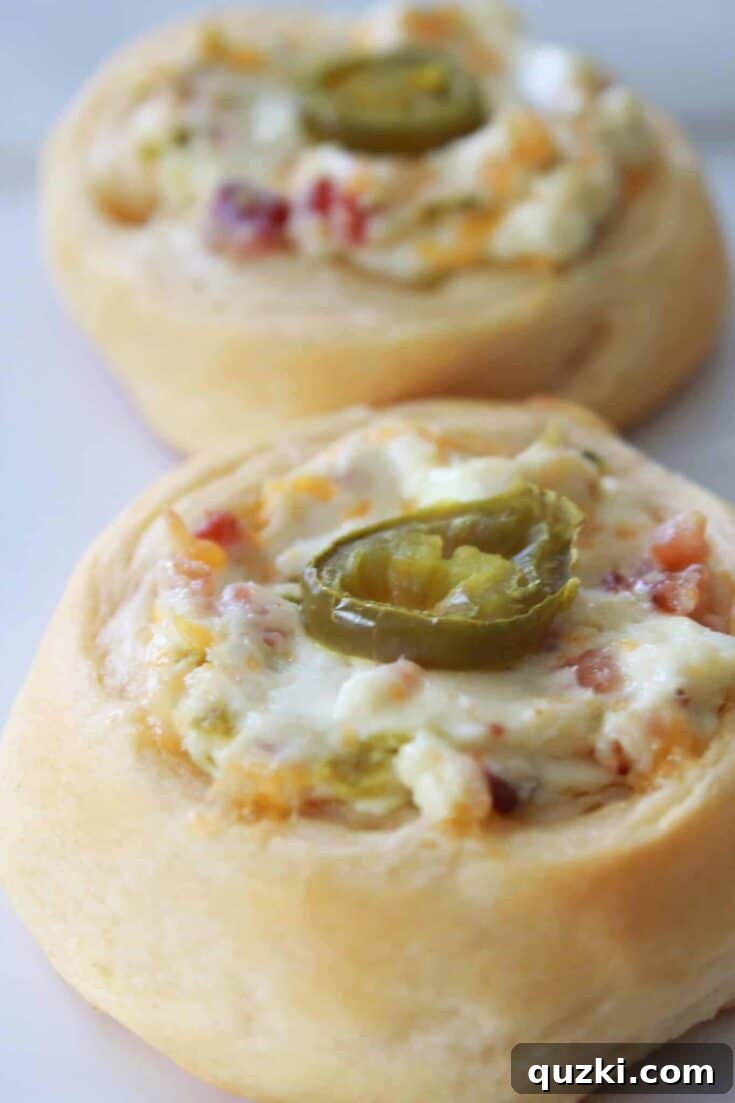Golden-baked Jalapeño Popper Crescent Bites, filled with a creamy, spicy blend of cheese and jalapeños, presented in individual crescent roll cups.