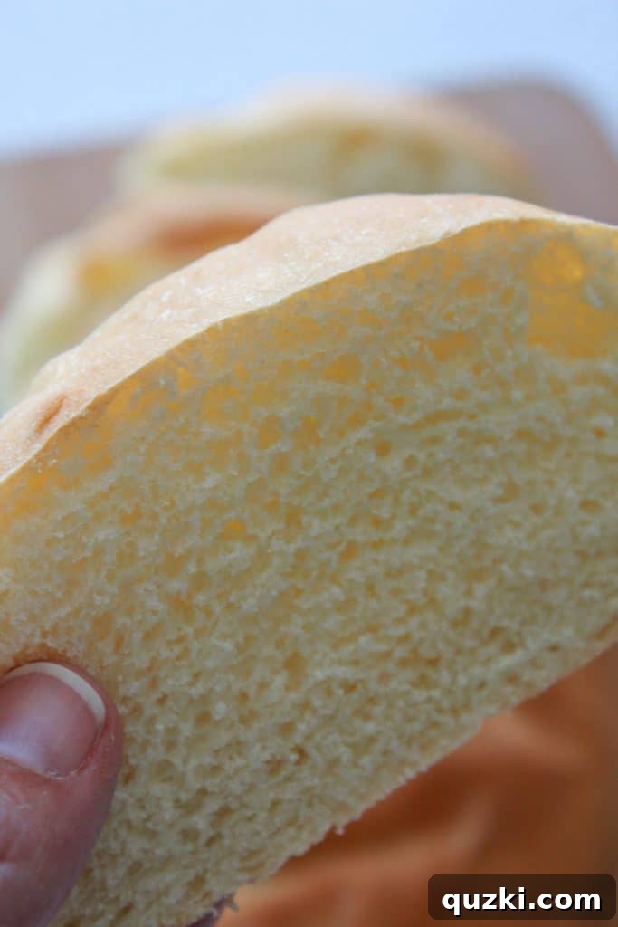 A warm slice of homemade French bread with melted butter, showcasing its soft interior and inviting texture.
