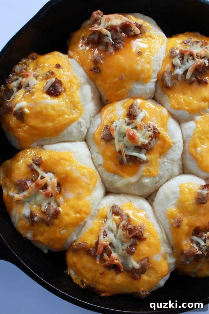 Freshly baked Skillet Sausage & Cheese Biscuits, golden brown with melted, bubbly cheese.