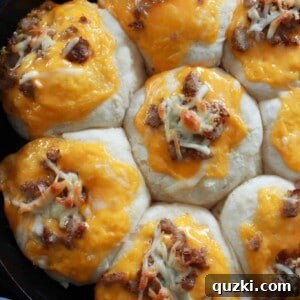 Close-up of a Skillet Sausage & Cheese Biscuit, showing the golden biscuit, sausage, and melted cheese layers.