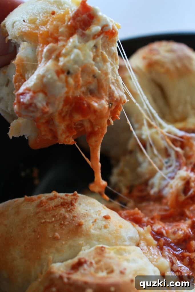 Close-up of the Pepperoni Pizza Biscuit Pull-Apart Dip showing an amazing cheese pull as a biscuit is lifted