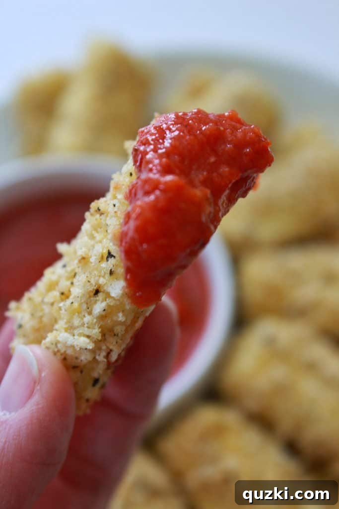 A bowl of warm pizza sauce, perfect for dipping homemade baked mozzarella sticks.