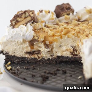 Looking inside a Snickers cheesecake that a has a few slices missing.