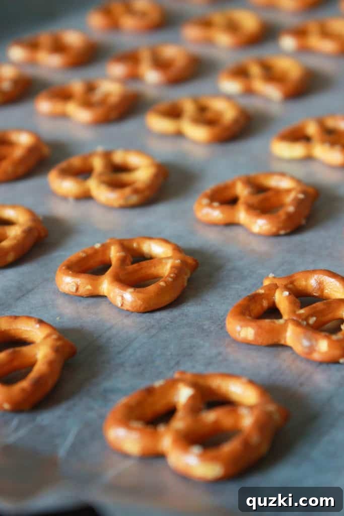 White Chocolate Dipped Pretzel Hearts 3 Mini pretzels arranged neatly in a single layer on wax paper, ready for filling with white chocolate for Valentine's Day treats.