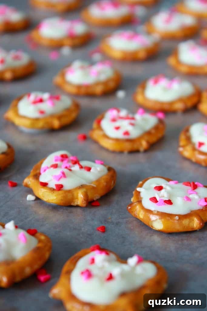 White Chocolate Dipped Pretzel Hearts 6 White chocolate filled pretzels being carefully decorated with colorful heart sprinkles, emphasizing the quick application needed.