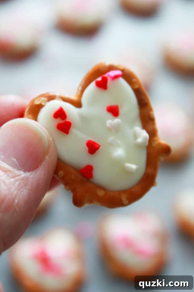 White Chocolate Dipped Pretzel Hearts 7 A single White Chocolate Pretzel Heart, perfectly set with colorful sprinkles, showcasing its delightful appearance.