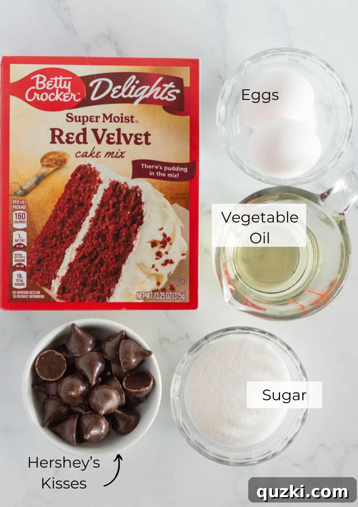 Effortless Red Velvet Kiss Cookies 3 A flat lay image displaying all the simple ingredients required to make Red Velvet Kiss Cookies: red velvet cake mix, eggs, vegetable oil, granulated sugar, and unwrapped Hershey's Kisses.