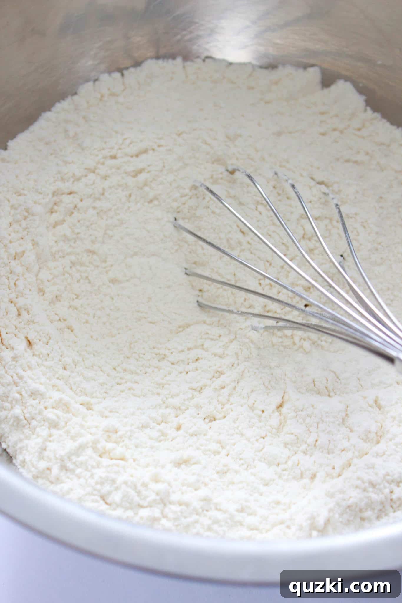Whisking the dry ingredients for Irish soda bread, including flour, sugar, baking soda, and salt, in a large bowl.
