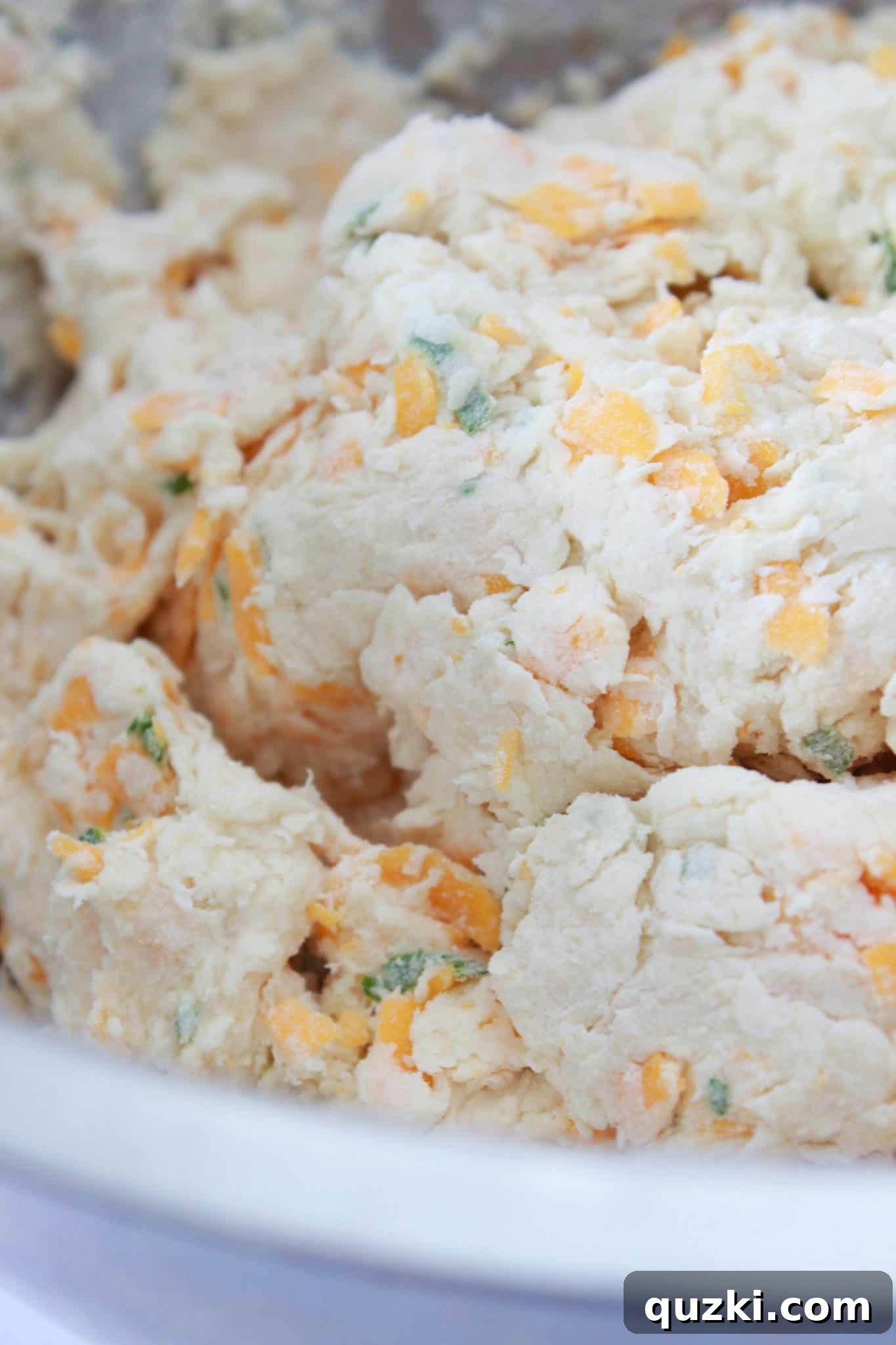 The process of making the cheddar and chive soda bread dough, showing its soft and slightly shaggy texture.