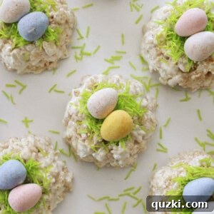 Close-up of a perfectly formed Rice Krispie Easter Nest on a plate, adorned with green sprinkles and three colorful candy eggs.