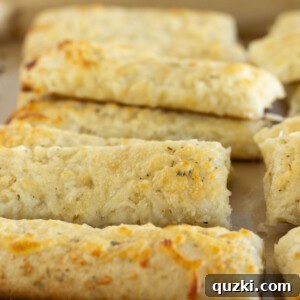 Cheesy breadsticks on a baking sheet.