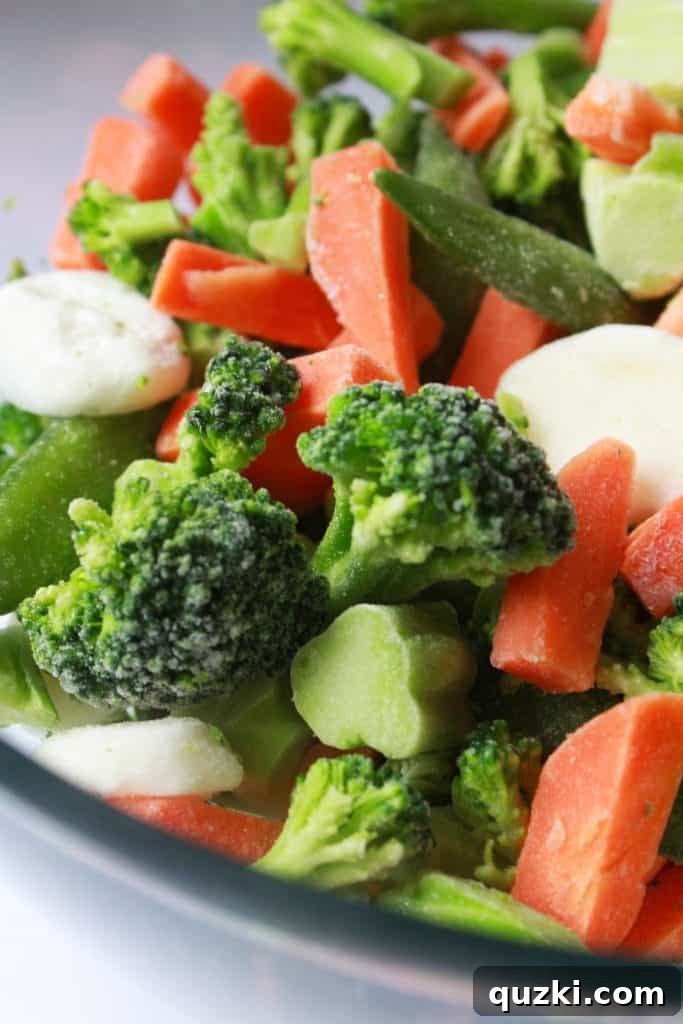 A bag of frozen stir-fry vegetables being prepared for cooking, showing broccoli, carrots, and snow peas.