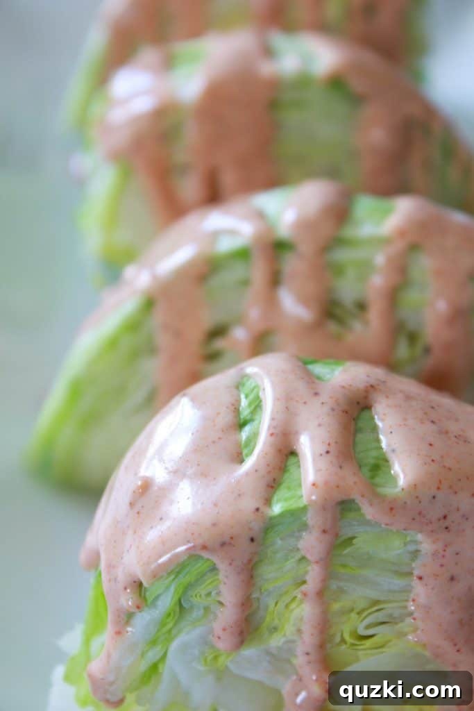 Vibrant Fiesta Wedge Salad 6 Creamy Fiesta Dressing being generously drizzled over a crisp iceberg lettuce wedge, preparing it for a vibrant array of toppings.