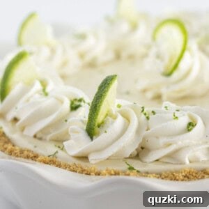 A key lime pie with homemade whipped cream and a graham cracker crust.