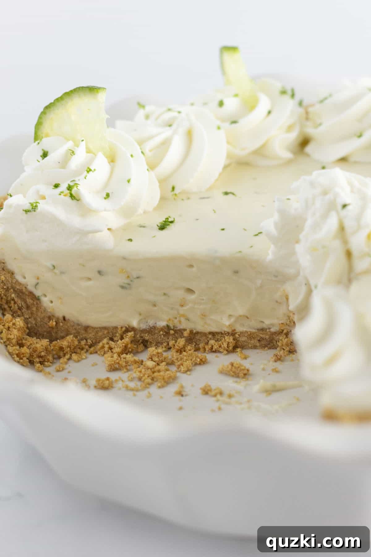 Showing the inside of a key lime pie with graham cracker crust, a perfect slice.