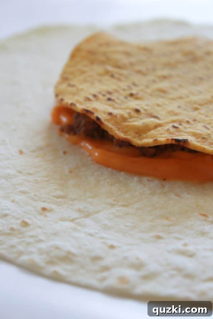 Golden Crunch Pocket 6 Step 3: Placing a crispy tostada shell over the ground beef layer.