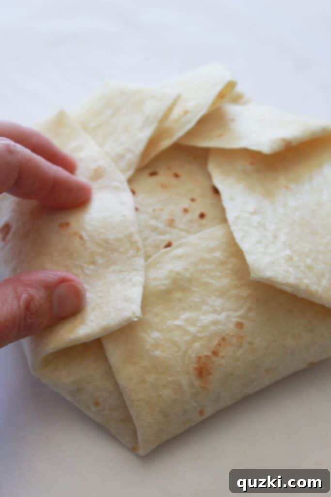 Golden Crunch Pocket 10 Step 7: Continuing to fold the tortilla all the way around the filling, creating a hexagonal shape, ready for cooking.