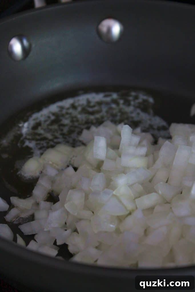 Onions beginning to caramelize in a skillet with butter