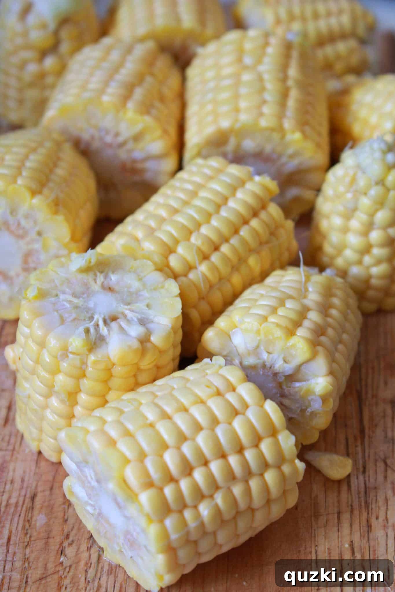 Ultimate Sheet Pan Shrimp Boil 4 Close-up shot showing the careful preparation of potatoes and corn on the cob, cut and ready for the Sheet Pan Cajun Shrimp Boil.