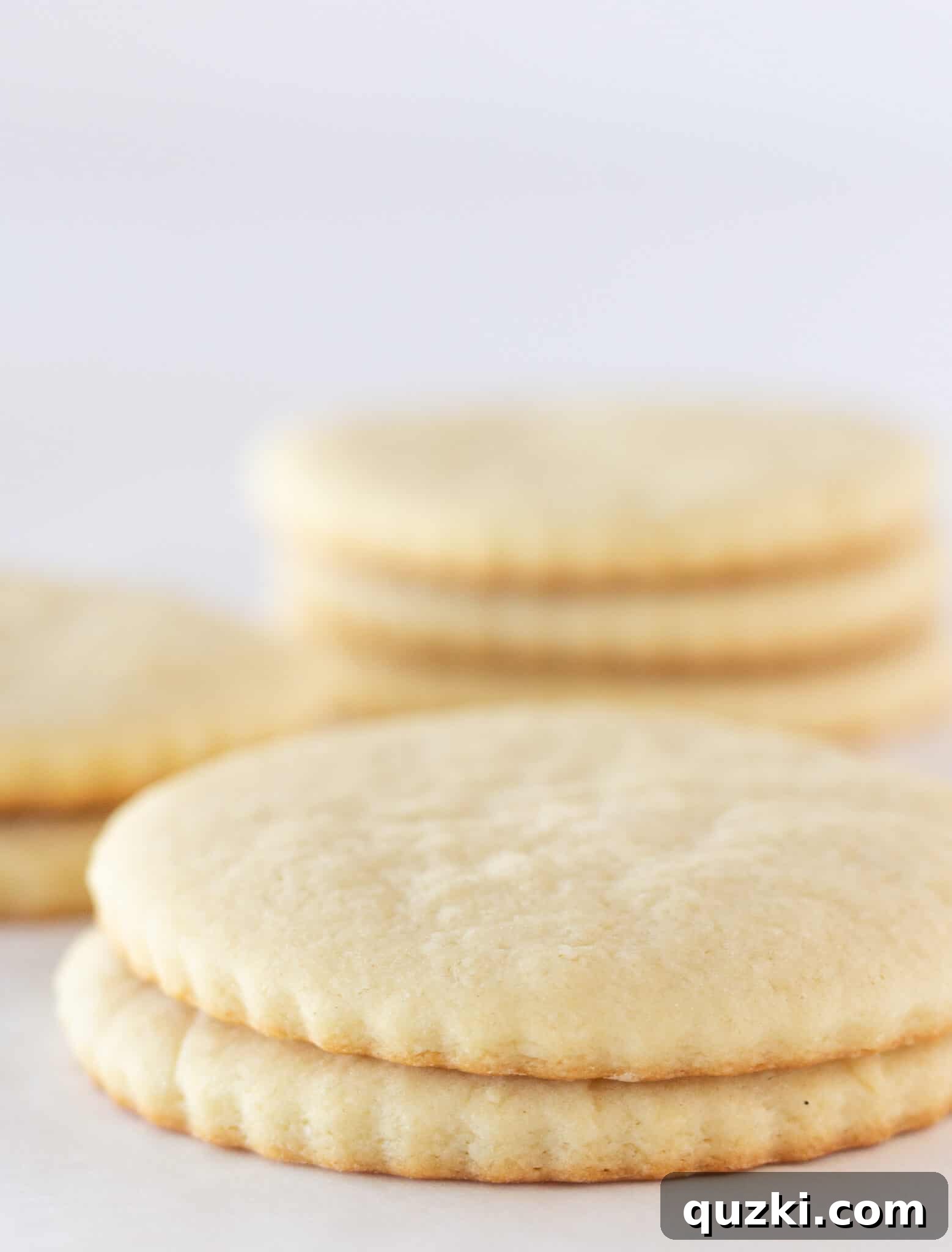 Effortless Cream Cheese Sugar Cookies 3 Stacks of unfrosted Easy Cream Cheese Sugar Cookies.