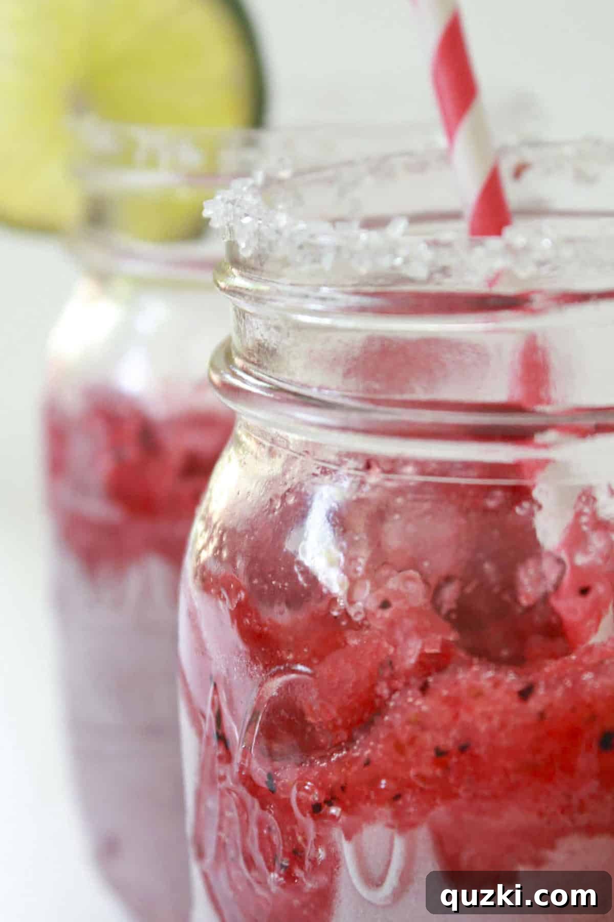 Vibrant Frozen Fruit Daiquiri 6 Beautifully garnished mixed fruit frozen daiquiris in mason jar glasses with sugared rims and fresh lime wedges.