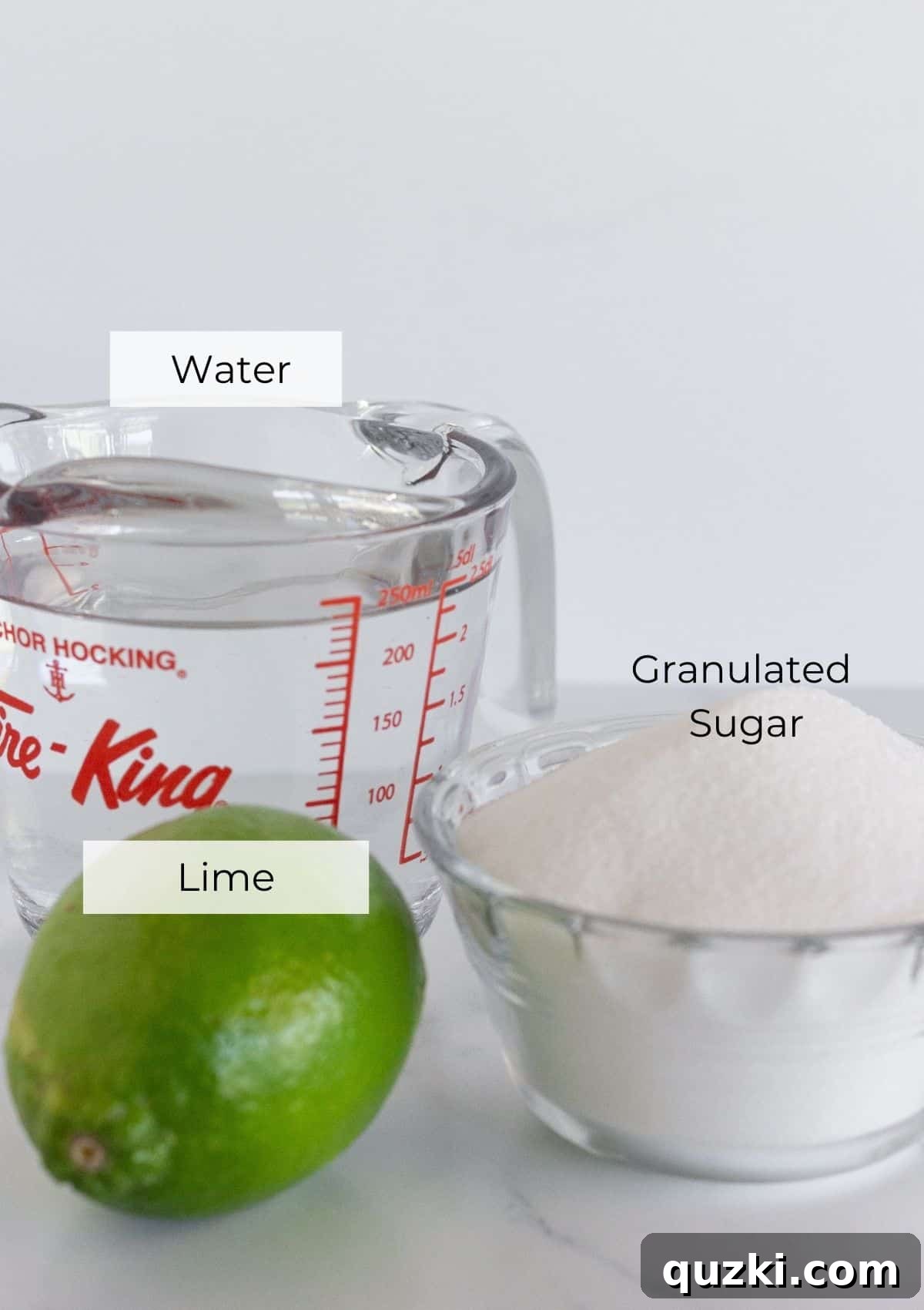 The three core ingredients laid out: granulated sugar, water, and fresh limes, essential for making the syrup.
