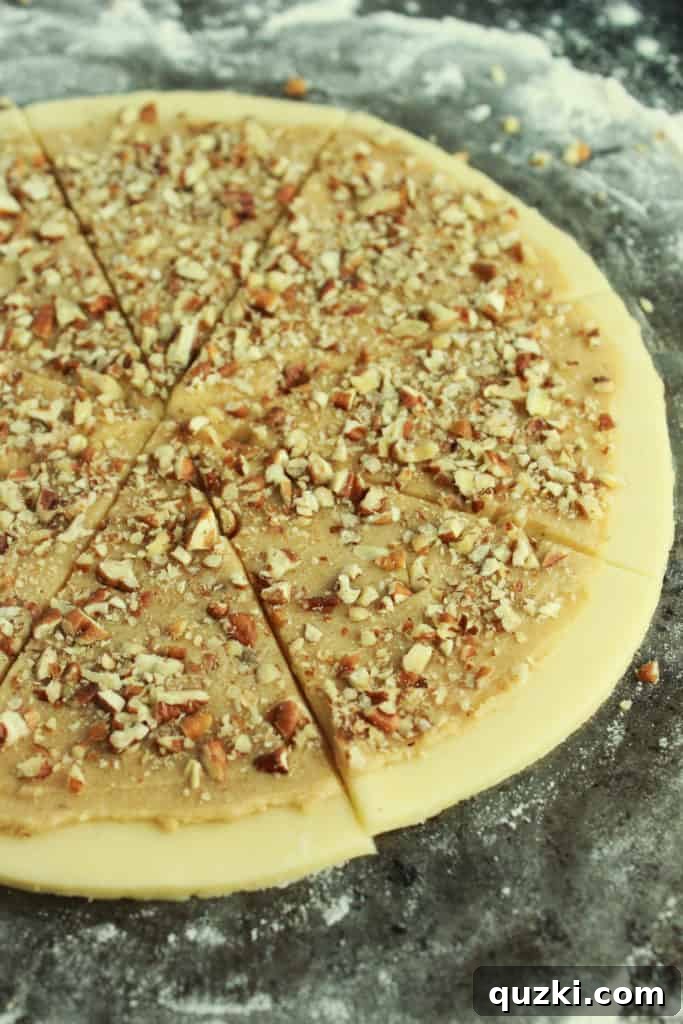 A perfectly rolled-out disc of cream cheese sugar cookie dough on a lightly floured surface, ready for filling.