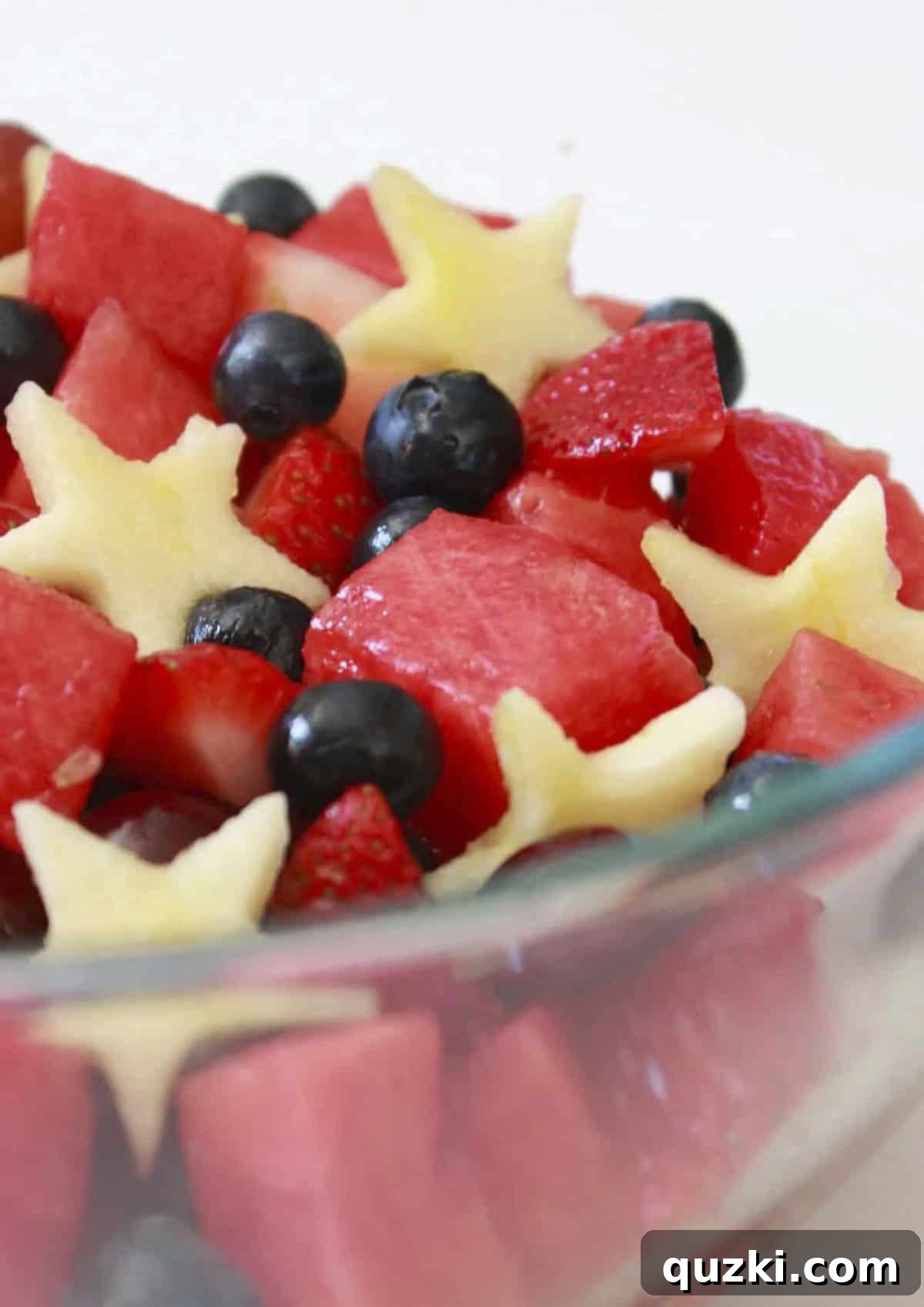 Patriotic Fruit Medley 7 A large glass bowl of 4th of July Fruit Salad, perfectly mixed and ready to be served, garnished with fresh mint.