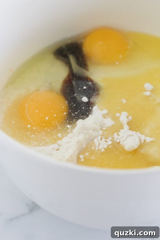 Combining the cake mix, vegetable oil, eggs, and vanilla extract in a large mixing bowl.