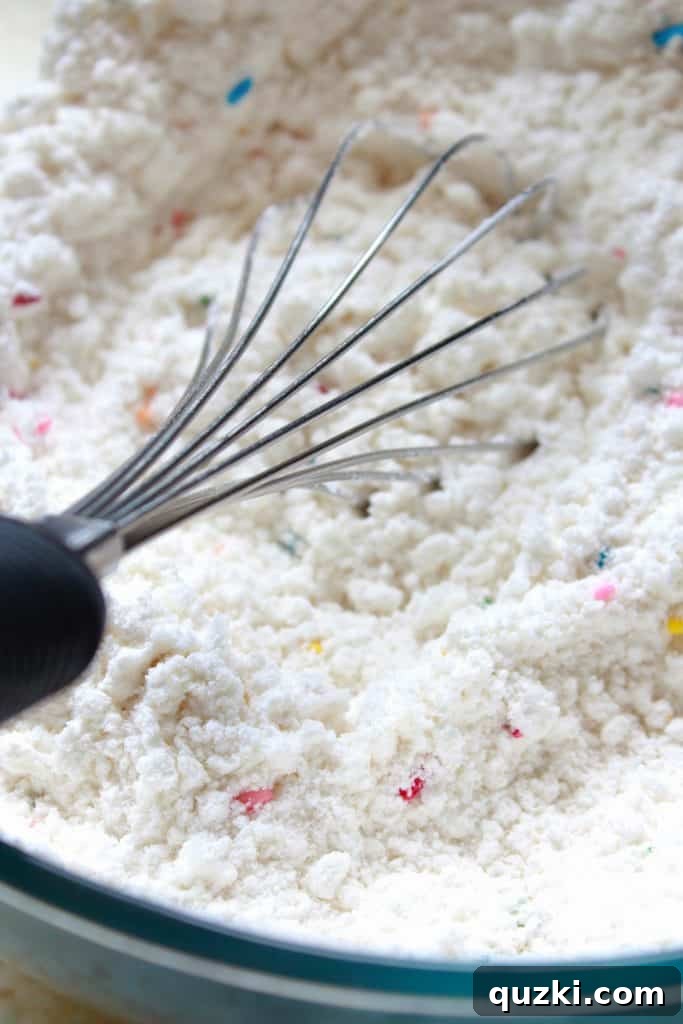 Festive Texas Sheet Cake Cookie Bites 4 Step 1: Whisking funfetti cake mix in a bowl for the Texas Sheet Cake Cookies recipe.