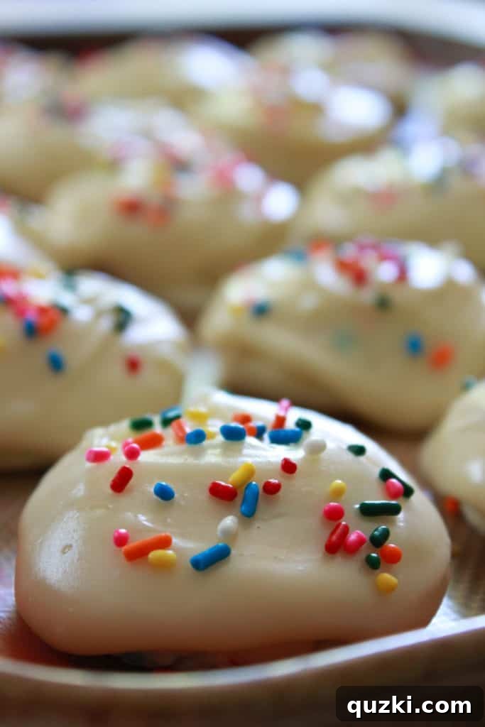 Festive Texas Sheet Cake Cookie Bites 9 Step 6: Frosting a cookie and immediately adding sprinkles before the frosting sets.