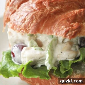 A close-up of a chicken salad sandwich on a croissant, enticing and delicious.