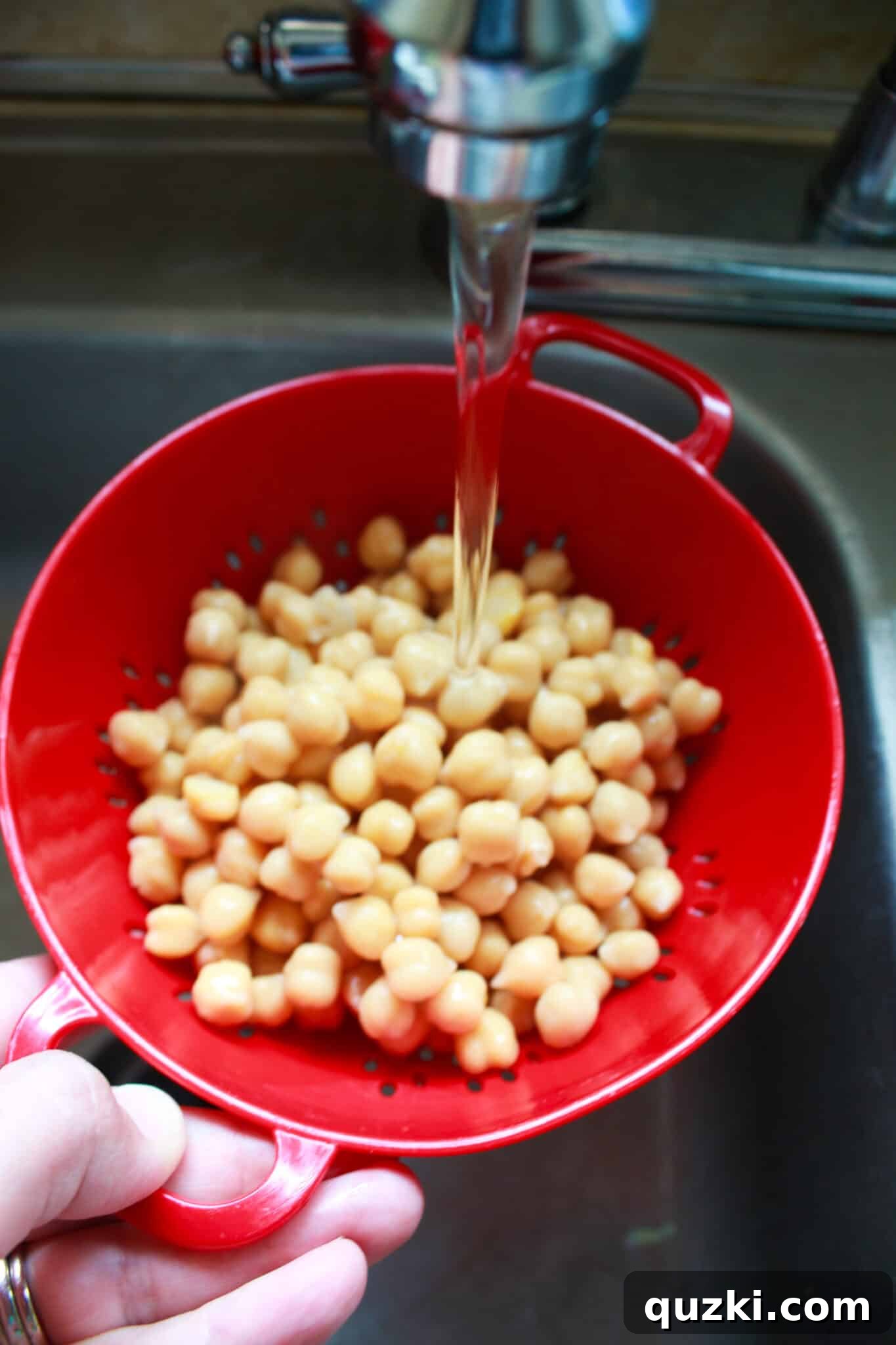 Rinsing chickpeas in a colander.
