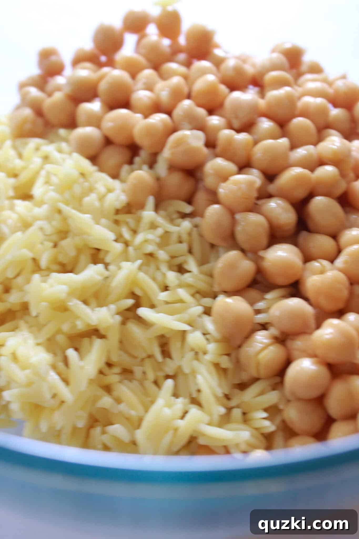 Cooked orzo and drained chickpeas in a mixing bowl.