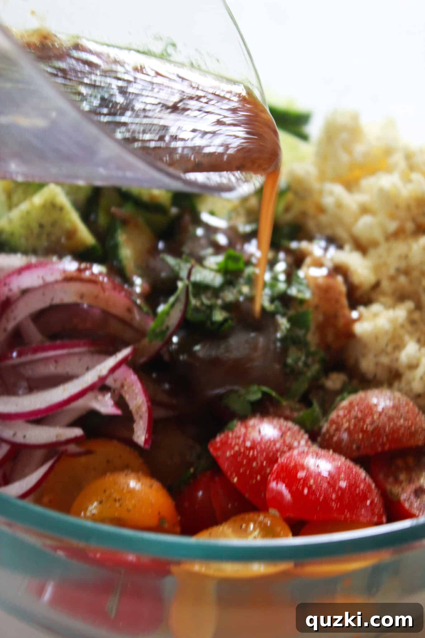 Pouring balsamic vinaigrette dressing over the Mediterranean Orzo Salad.