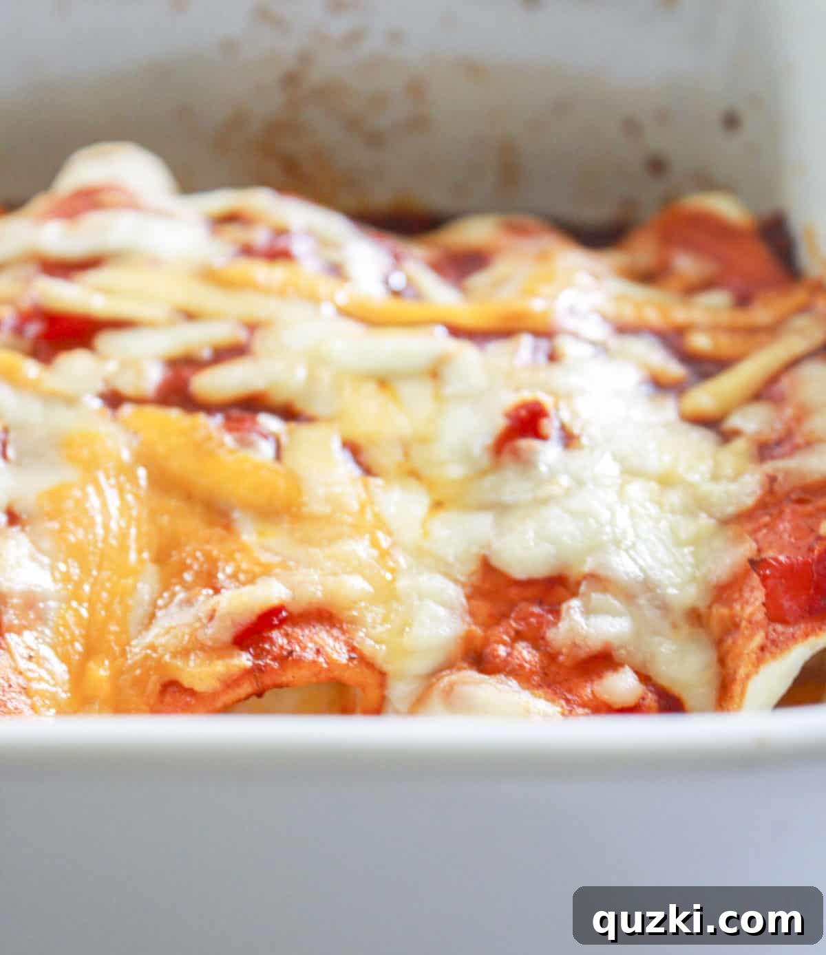 Flavorful Shrimp Enchiladas in a Flash 6 A freshly baked shrimp enchiladas casserole presented in a white baking pan, showcasing the golden-brown melted cheese and bubbling sauce, ready to be served.