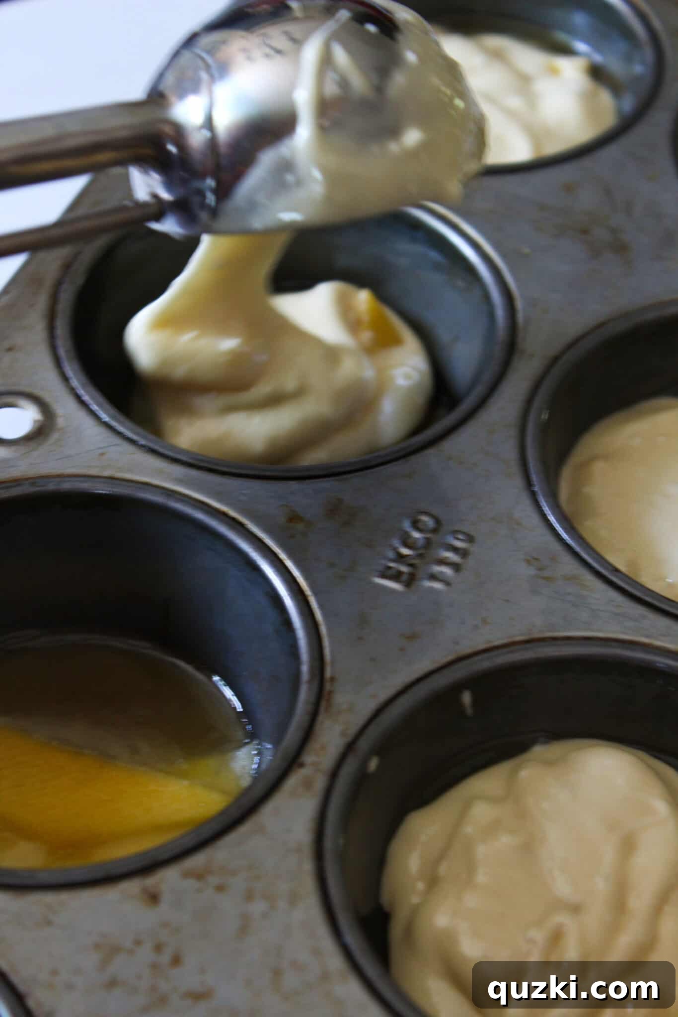 Effortless Peach Flip Cupcakes 8 Cupcake batter scooped into muffin cups over peaches and brown sugar, ready for baking.